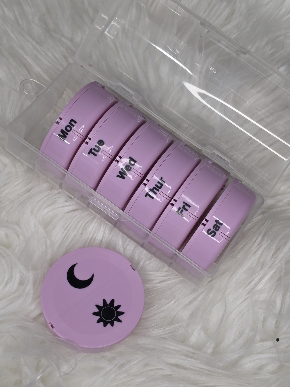 Pink pill organizer with moon and sun design